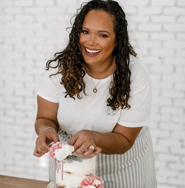 Magali smiling while decorating a cake
