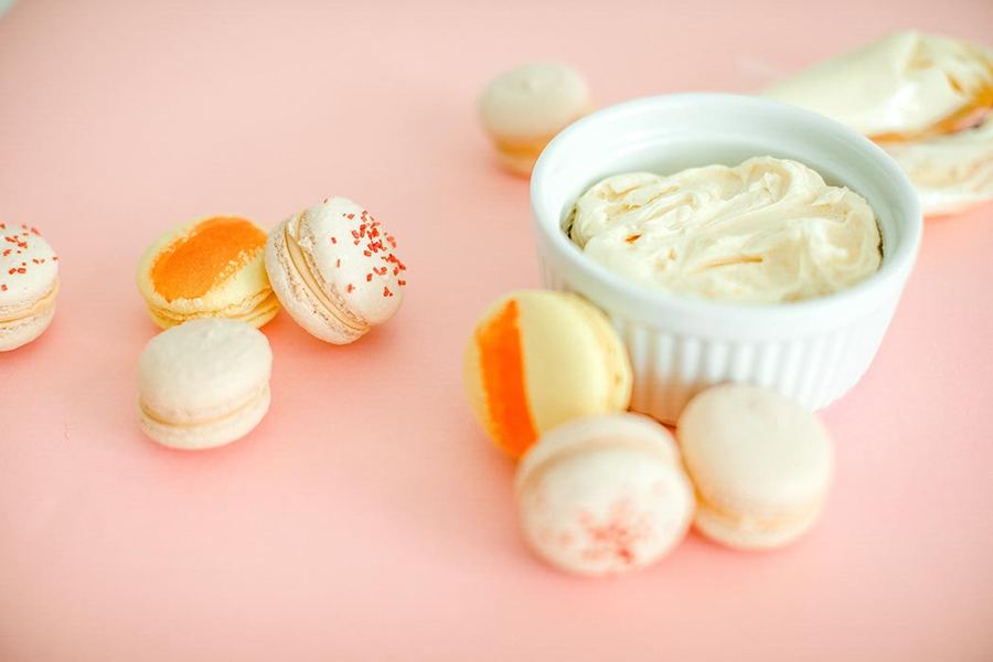 Macarons with a bowl of filling on pink