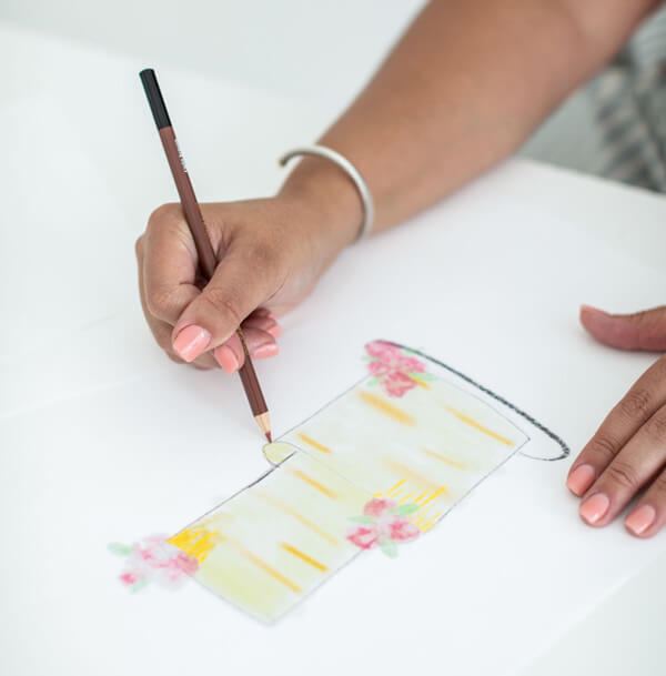 Magali sketching a cake design by hand with a watercolor wash