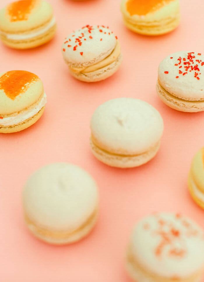 Macarons in cream and coral arranged on pink